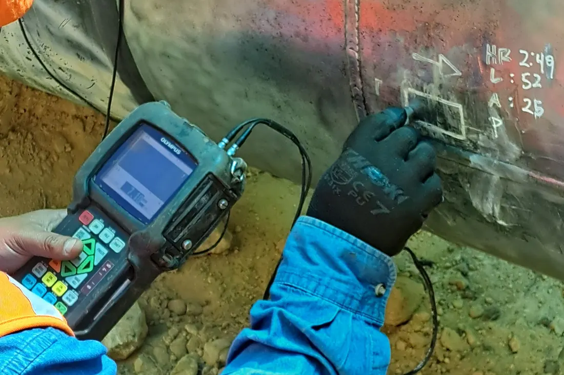 Técnico mide el espesor de la tubería del gasoducto con un equipo de ultrasonido